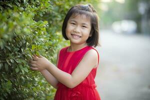 lief Aziatisch meisje vervelend rood rok jurk in beweging met geluk gezicht buitenshuis foto