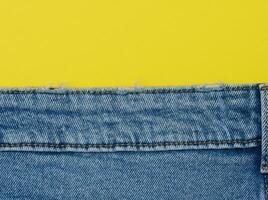 blauw jeans Aan een geel achtergrond, kopiëren ruimte foto