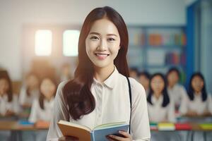 portret van gelukkig Aziatisch leraar met een boek in school, jong vrouw tutor glimlachen en op zoek Bij de camera foto