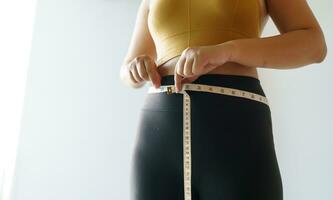 vrouw willen naar verliezen gewicht met een centimeter vorm omhoog gezond maag spier en eetpatroon meten taille met meten plakband na eetpatroon gewicht controle foto