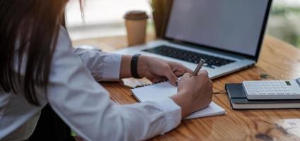 zijaanzicht en close-up van de handen van de vrouw met behulp van laptop foto