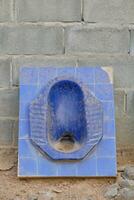 oud blauw gebroken hurken toilet foto