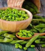 groene sojabonen in de houten kom op tafel foto