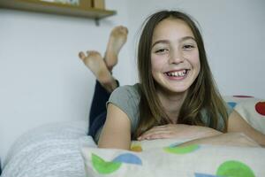 portret van lachend meisje aan het liegen Aan bed foto