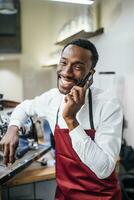 gelukkig barista Aan de telefoon in een koffie winkel foto