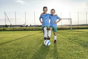 glimlachen jong Amerikaans voetbal spelers omarmen Aan Amerikaans voetbal grond foto