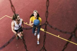 jong Mens en vrouw spelen basketbal Aan basketbal grond foto