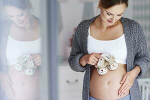 zwanger vrouw met baby slofjes foto