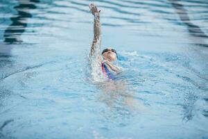 jong vrouw zwemmen in zwemmen zwembad, rugslag foto