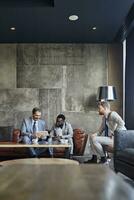 drie zakenlieden zittend in hotel lobby met tablet foto