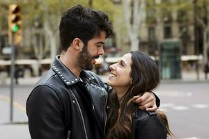 Spanje, Barcelona, gelukkig jong paar knuffelen Aan de straat foto
