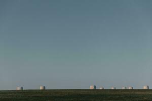 balen van rietje verpakt in plastic Aan horizon gedurende zonsopkomst foto