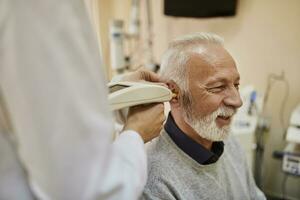 ent arts onderzoeken oor van een senior Mens foto