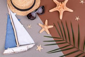 strandaccessoires, bril en hoed met schelpen en zeesterren op een gekleurde achtergrond. zomer achtergrond foto