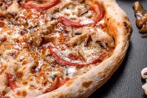 verse heerlijke Italiaanse pizza met champignons en tomaten op een donkere betonnen ondergrond concrete
