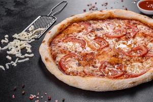 verse heerlijke Italiaanse pizza met champignons en tomaten op een donkere betonnen ondergrond concrete