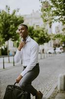 jonge Afro-Amerikaanse zakenman waitng een taxi in een straat foto