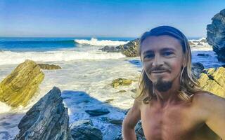 selfie met rotsen kliffen visie golven strand puerto escondido Mexico. foto