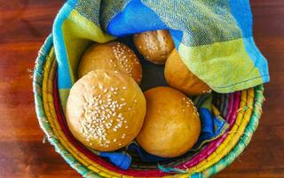 heerlijk ronde broodjes met sesam zaden Aan houten tafel Mexico. foto