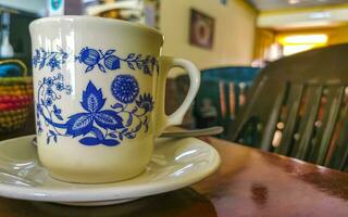 blauw wit kop pot met zwart koffie houten tafel Mexico. foto