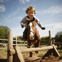 een jongen jumping over- een horde met zijn hobby paard foto