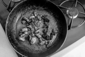 mooie gefrituurde champignonschampignon in gietijzeren pan op de achtergrond foto