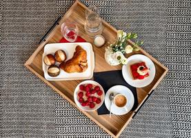 ontbijt op bed. frambozen, koffie, cake, croissant. gezellig hotelletje. foto