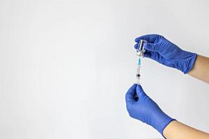 een medisch werker in medische handschoenen trekt een dosis coronavirusvaccin in een spuit. het concept van vaccinatie, immunisatie, preventie van mensen van covid-19 foto