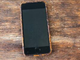 roestig oud mobiel telefoon Aan een houten achtergrond foto