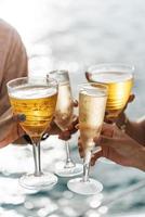 hand met een glas wijn drinken op zonsondergang zee achtergrond. foto