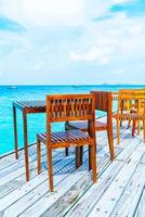 lege houten tafel en stoel buiten met uitzicht op zee op de Malediven foto