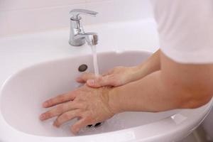 handen wassen in wastafel foto