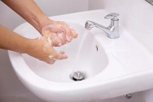 handen wassen in wastafel foto