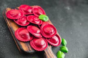 ravioli biet kleurstof pasta rood kleur Koken voorafje maaltijd voedsel tussendoortje Aan de tafel kopiëren ruimte voedsel achtergrond rustiek top visie foto