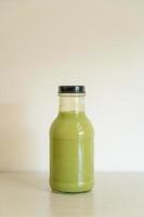 matcha groene thee latte in glazen fles op tafel foto