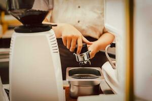 barista voorbereiding knoeien koffie in filterhouder voor maken vers koffie. foto