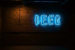 wijnoogst bier neon teken Aan donker steen muur met mok foto
