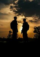 silhouetten van twee soldaten staand sterk tegen de zonsondergang lucht foto