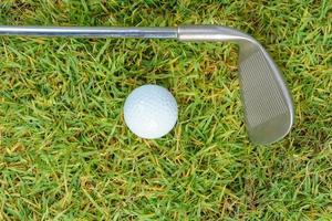 golfclubs en golfbal op groene grasachtergrond foto