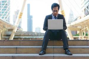 zakenman zittend op de voetstappen met laptop foto