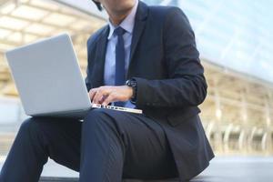 zakenman zittend op de voetstappen met laptop foto