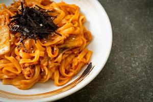 roergebakken udon noedels met kimchi en varkensvlees - koreaanse voedselstijl foto