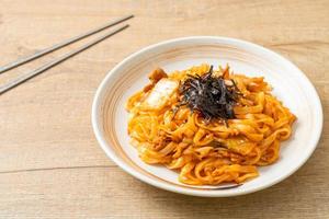 roergebakken udon noedels met kimchi en varkensvlees - koreaanse voedselstijl foto