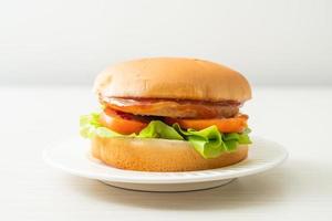 kipburger met saus op wit bord foto