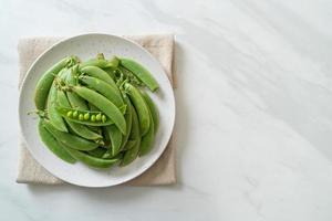 verse zoete groene erwten op witte plaat foto