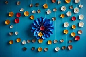 een blauw muur met papier bloemen hangende van het. ai-gegenereerd foto