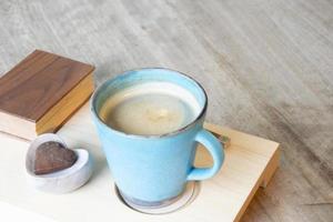 hete cappuccino in kopje op houten tafel foto
