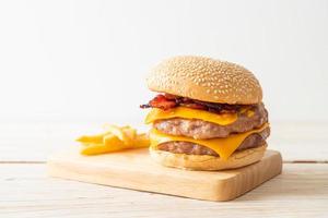 varkenshamburger of varkensburger met kaas, spek en frietjes foto