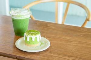 Matcha groene thee cheesecake met groene thee beker op tafel in café restaurant foto