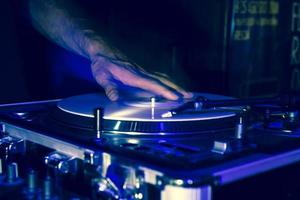 handen van een dj tijdens het draaien van vinylplaten op een feestje foto